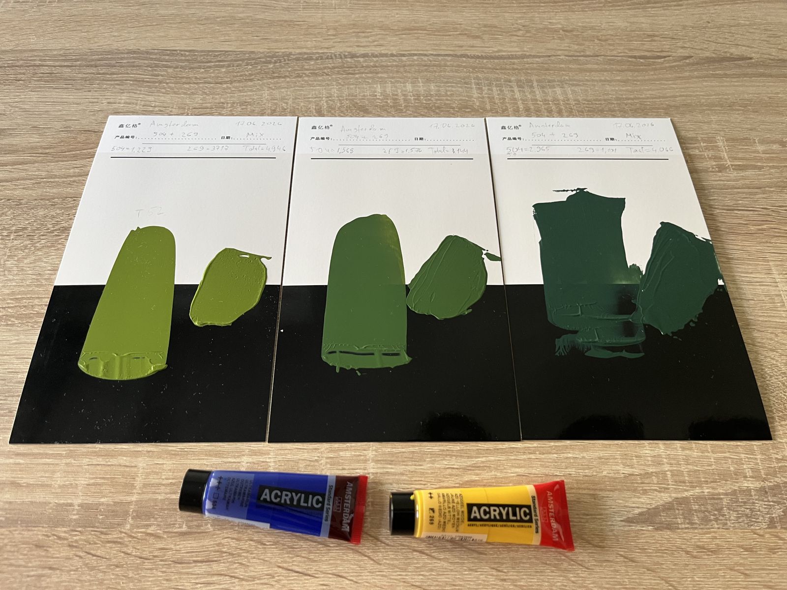 Three green mixes of ultramarine and yellow drawn down over white and black.